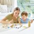 Gros plan sur une femme et un enfant s'amusant avec le jeu Bamboo Rapido Combining, entourés d’accessoires du jeu.