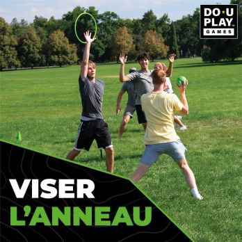 Groupe de jeunes jouant à Bamzball sur une pelouse, un joueur tente de viser un anneau avec une balle verte.