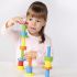 Petite fille concentrée construisant une tour avec les pièces en bois colorées du jeu d'équilibre Torreta Beleduc