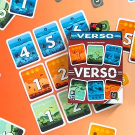 Boîte du jeu Verso au centre d’un plateau de jeu multicolore avec des cartes rangées autour.