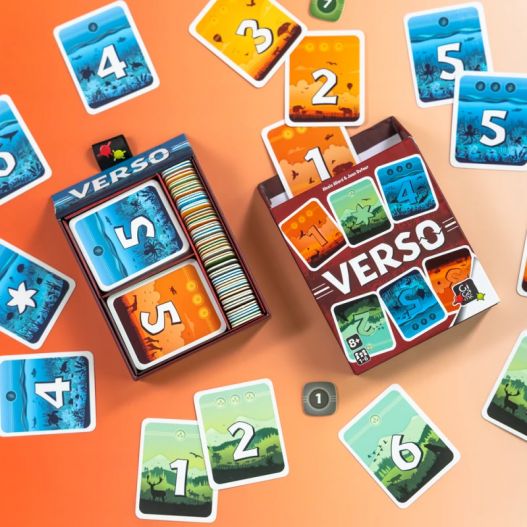 Boîte ouverte du jeu Verso montrant les cartes classées et les jetons à l’intérieur, entourée de cartes posées sur la table.