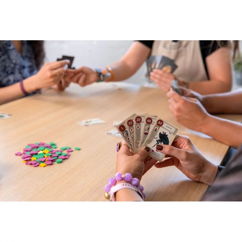 Partie en cours du jeu Once Upon a Draft, des joueurs tiennent des cartes en main et utilisent des jetons colorés.