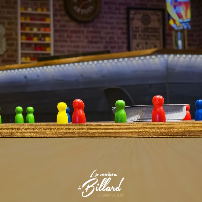 Jeu de Tock en bois en situation, posé sur une table de bar avec ambiance chaleureuse.