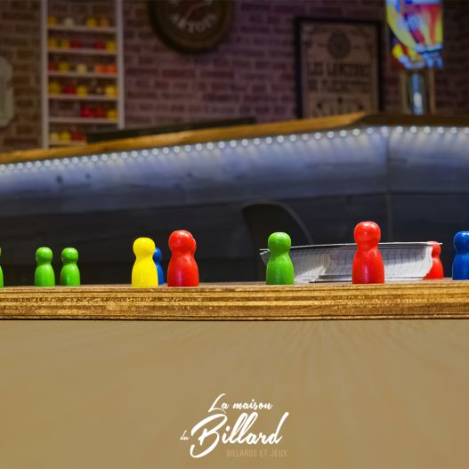 Jeu de Tock en bois en situation, posé sur une table de bar avec ambiance chaleureuse.