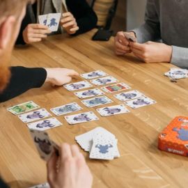 Zoom sur les cartes posées au centre d'une table avec des joueurs en pleine partie de 6 qui prend !