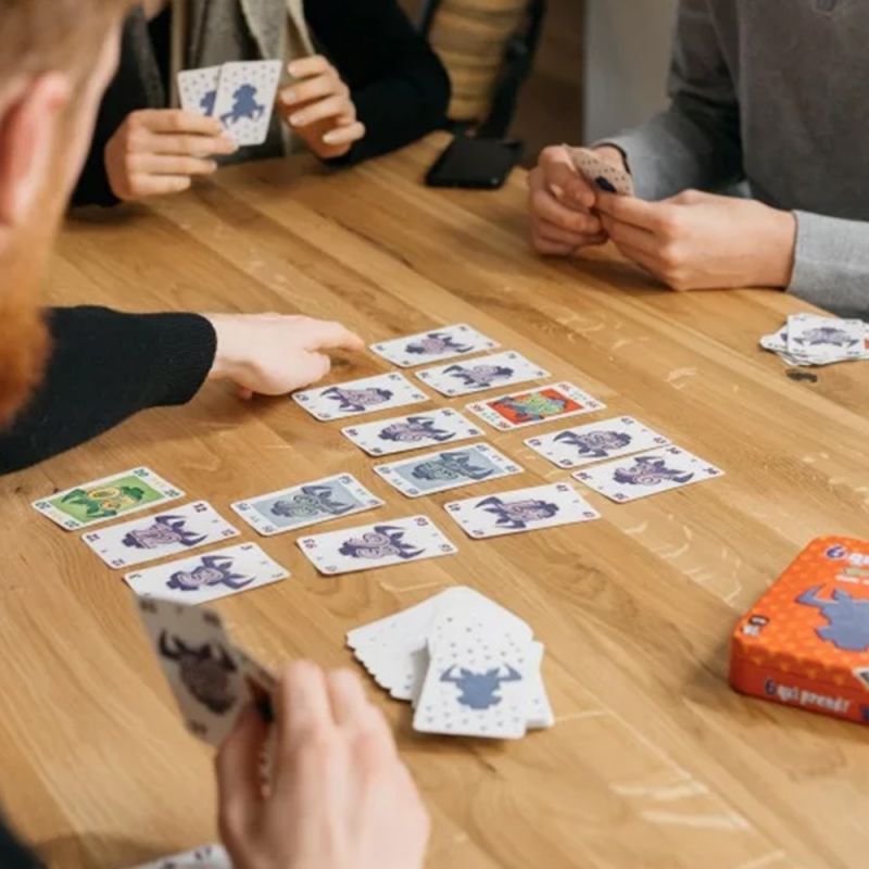 Zoom sur les cartes posées au centre d'une table avec des joueurs en pleine partie de 6 qui prend !