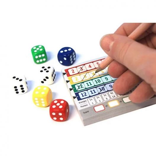 Main de joueur cochant une grille de score Qwixx avec des dés autour.
