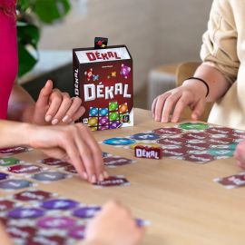 Gros plan sur les mains des joueurs manipulant les cartes du jeu DÉKAL.