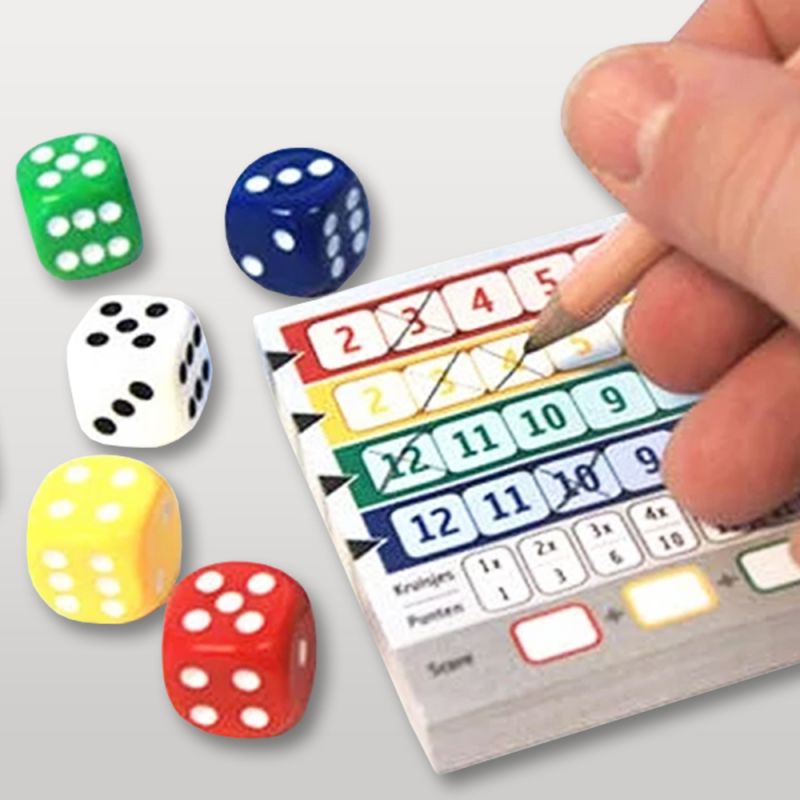 Main de joueur cochant une grille de score Qwixx avec des dés autour.