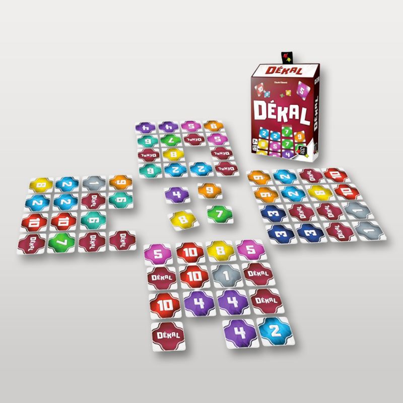 Vue complète du matériel du jeu DÉKAL avec la boîte et les cartes étalées en grille.