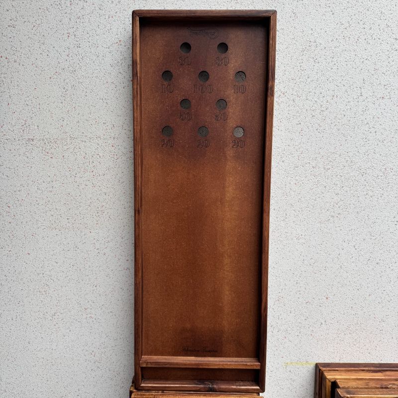 billard japonais en bois debout contre un mur, avec ses dix trous numérotés et son logo estampé