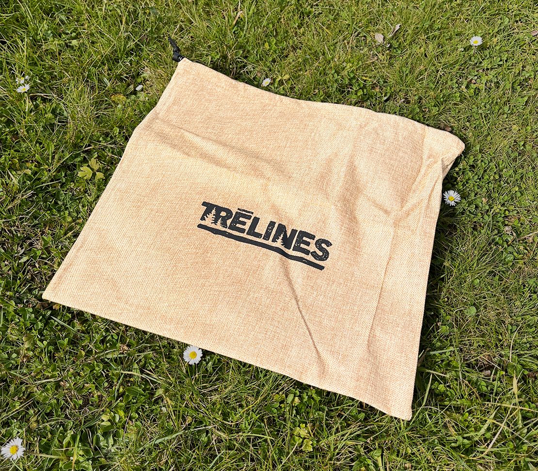 Sac de rangement beige du Kit Ninja Adventure Trelines posé sur l'herbe.